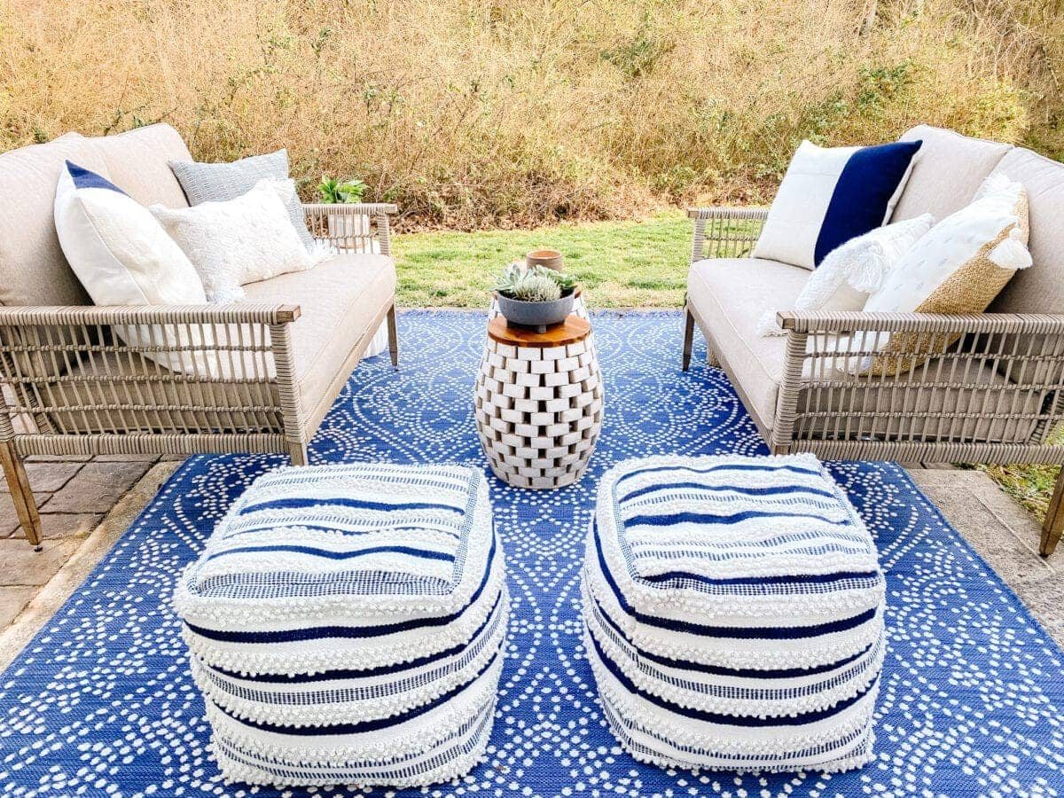 outdoor poufs and rug covering a small patio