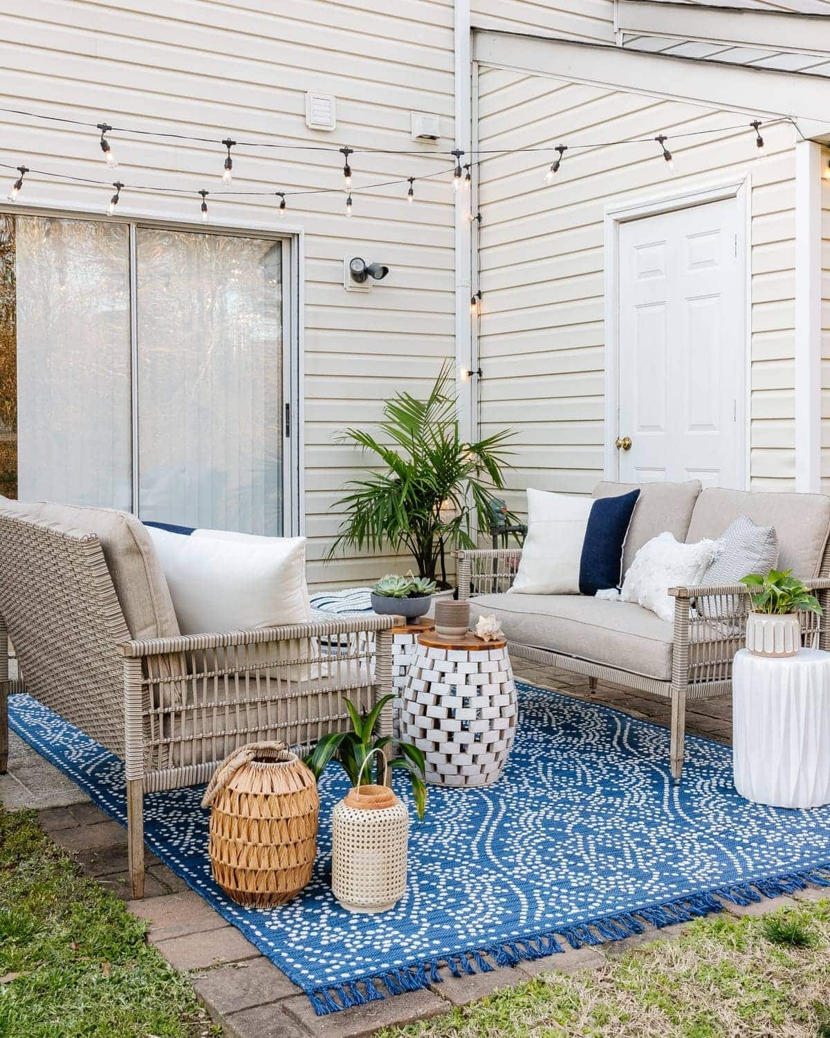 backyard patio styled with outdoor furniture and plants behind a townhouse