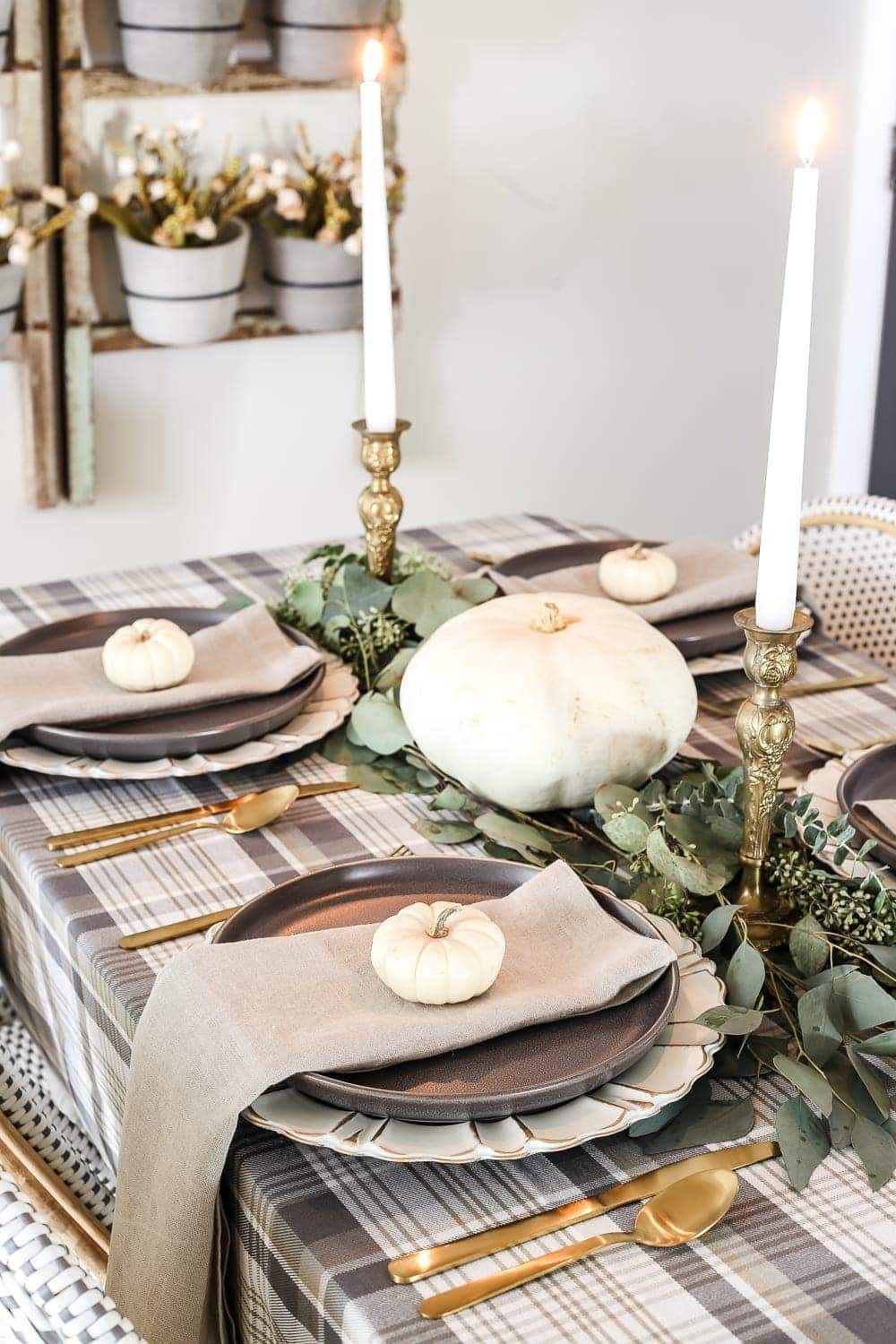 Neutral Low-Key Thanksgiving Tablescape | unigumushane.com - A neutral low-key Thanksgiving tablescape that is simple and inexpensive to recreate using plaid fabric, white pumpkins, eucalyptus, and brass.