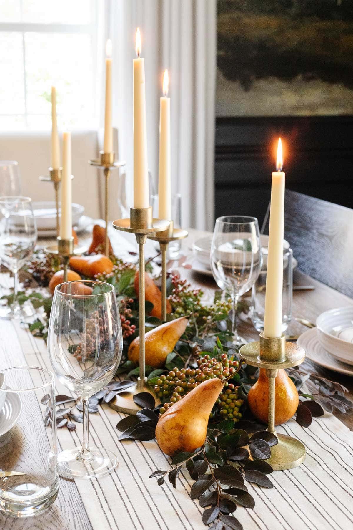 Thanksgiving dining table centerpiece with leaves and pears and candlesticks