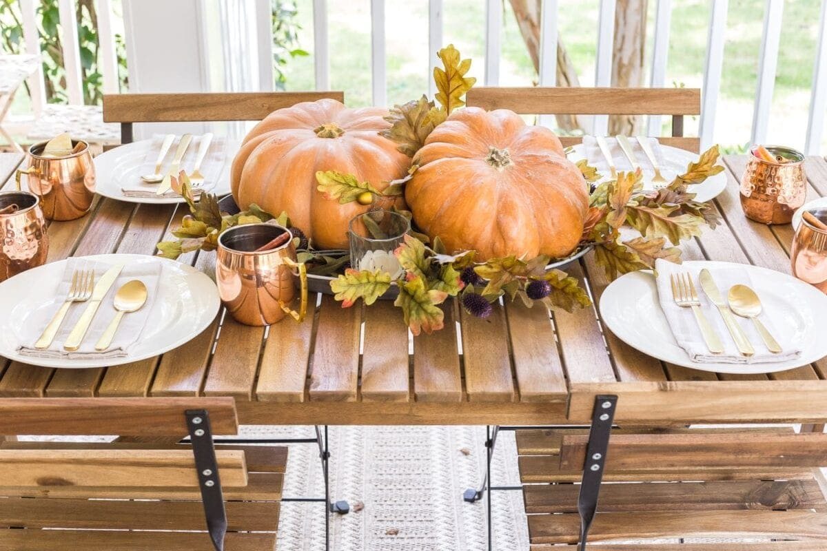 cozy fall porch with outdoor dining and simple pumpkin centerpiece