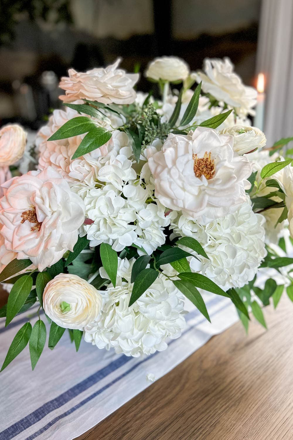 classic DIY flower arrangement with fake hydrangeas, roses, ranunculus, ruscus, and eucalyptus