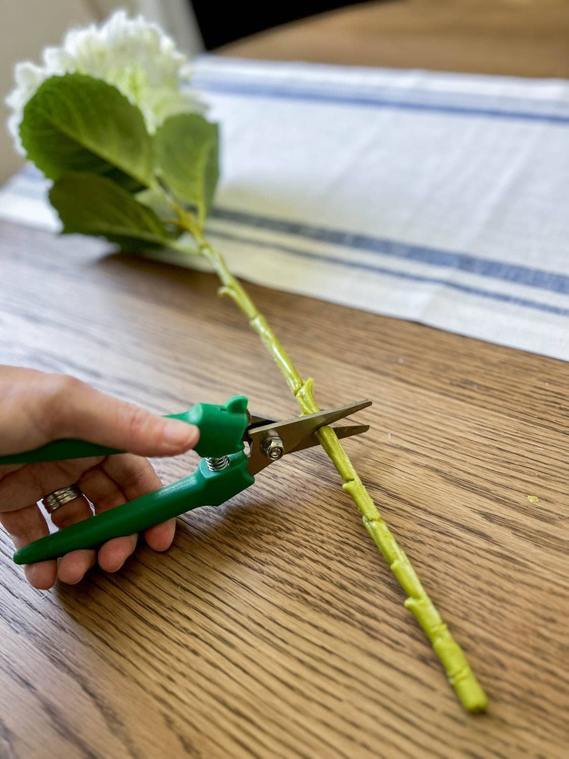 cutting a faux flower for a floral arrangement