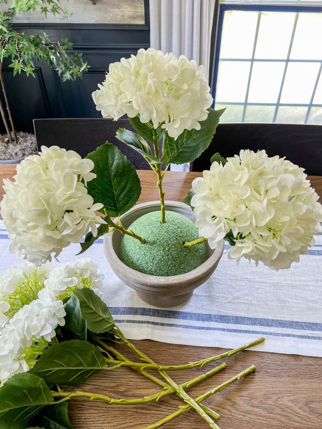 placing faux flowers in odd numbers to arrange in foam to make wedding altar flowers