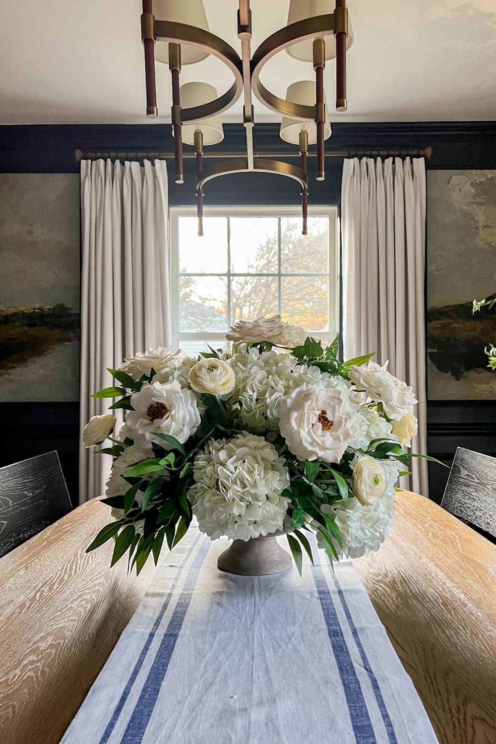 white flower arrangement wedding centerpiece with fake hydrangeas, roses, ranunculus, ruscus, and eucalyptus