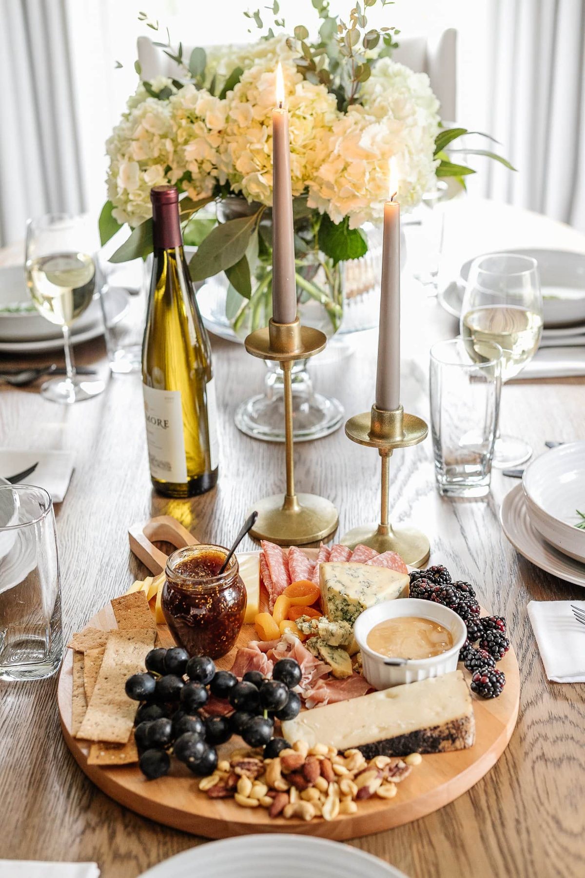 charcuterie board, candlesticks, and vase of flowers for simple dinner table decor