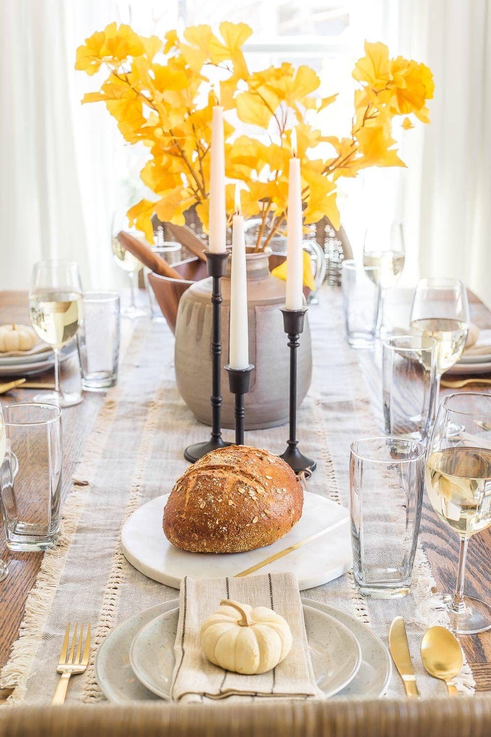 fall dinner table decor with vase of ginkgo stems
