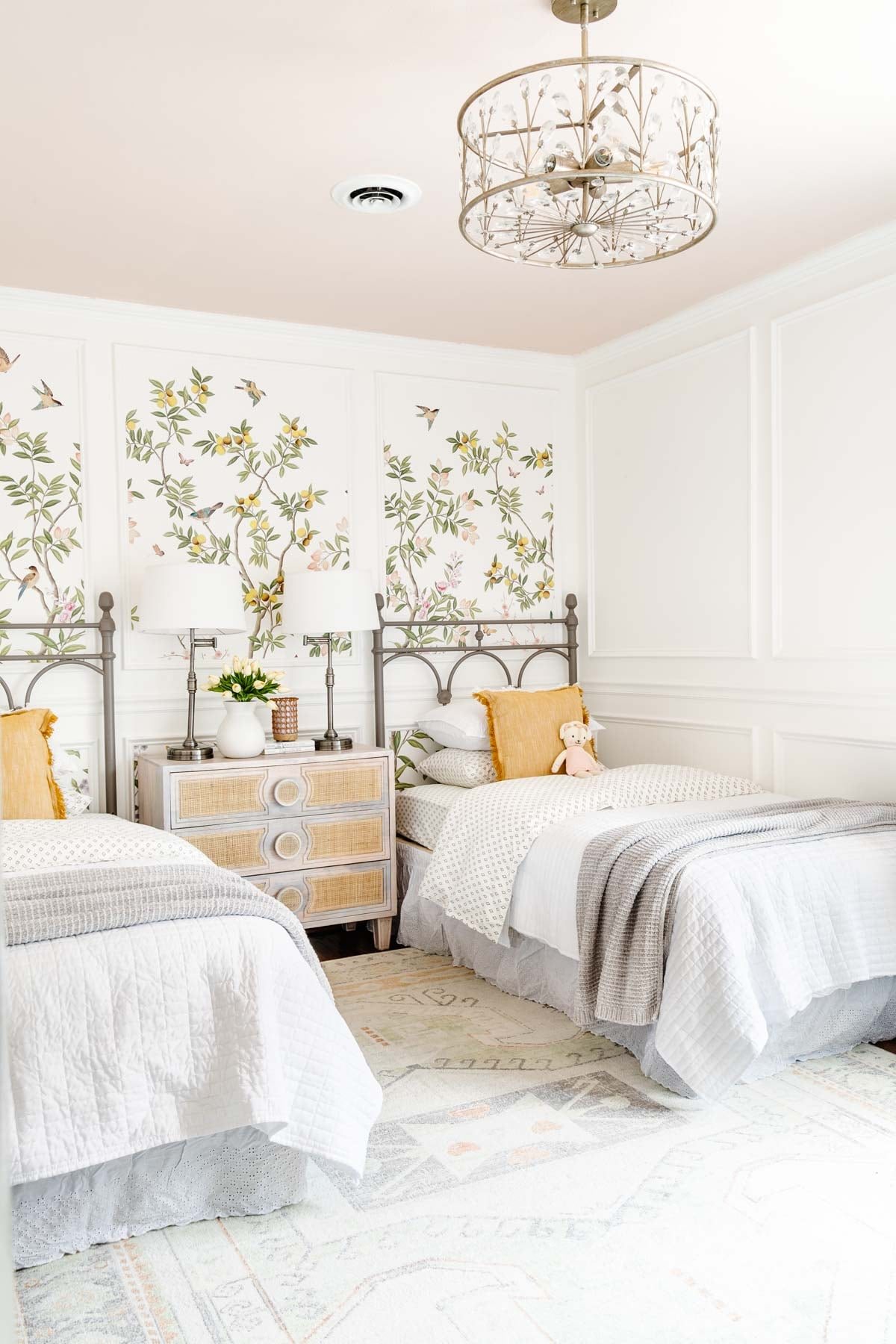 cottage toddler bedroom with chinoiserie wallpaper, picture frame molding, twin beds, and blush pink ceiling in Romabio Barefoot Dance