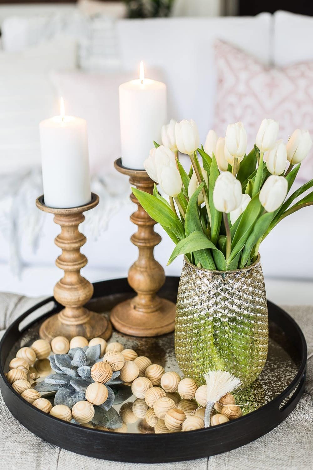 A living room gets a spring refresh with simple florals, candle light, and light fabrics. #springdecor #livingroom #springlivingroom #springaccents #livingroomdesign #livingroomdecor #budgetdecor