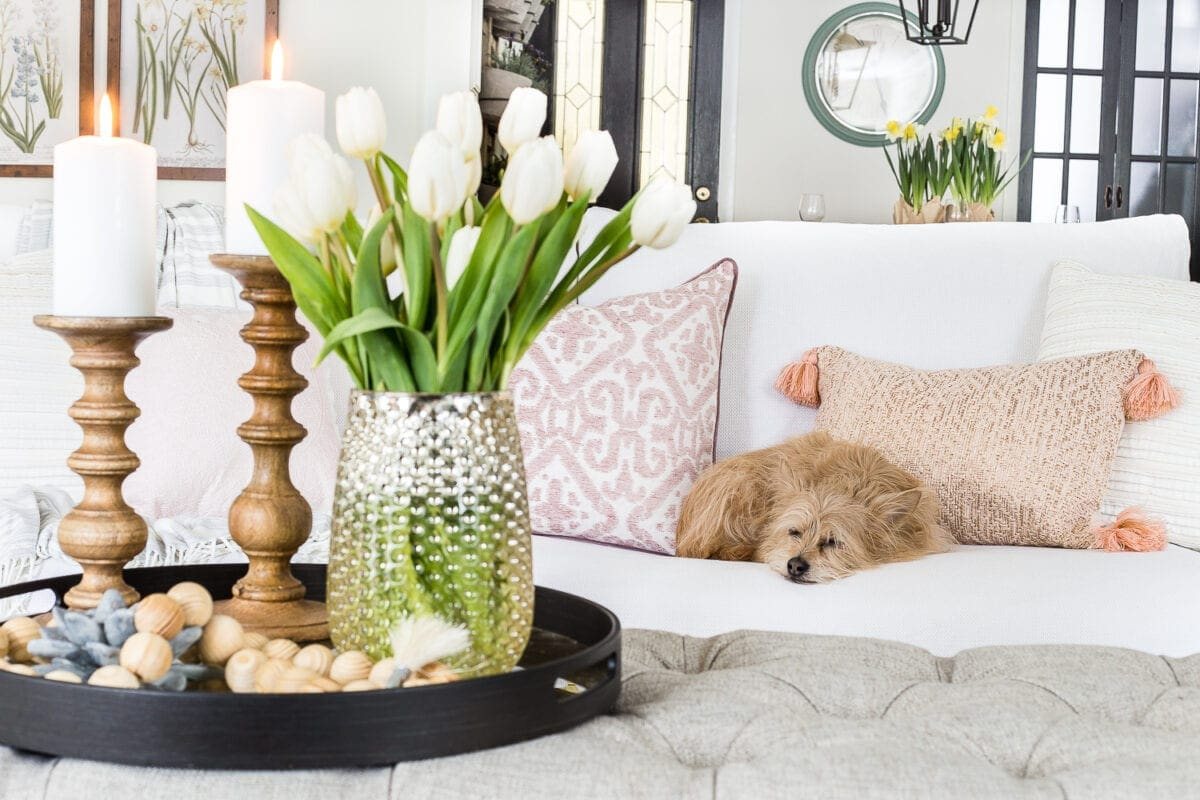 A living room gets a spring refresh with simple florals, candle light, and light fabrics. #springdecor #livingroom #springlivingroom #springaccents #livingroomdesign #livingroomdecor #budgetdecor