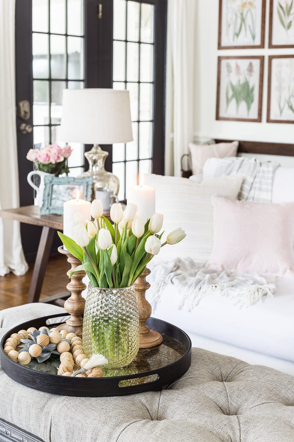 A living room gets a spring refresh with simple florals, candle light, and light fabrics. #springdecor #livingroom #springlivingroom #springaccents #livingroomdesign #livingroomdecor #budgetdecor
