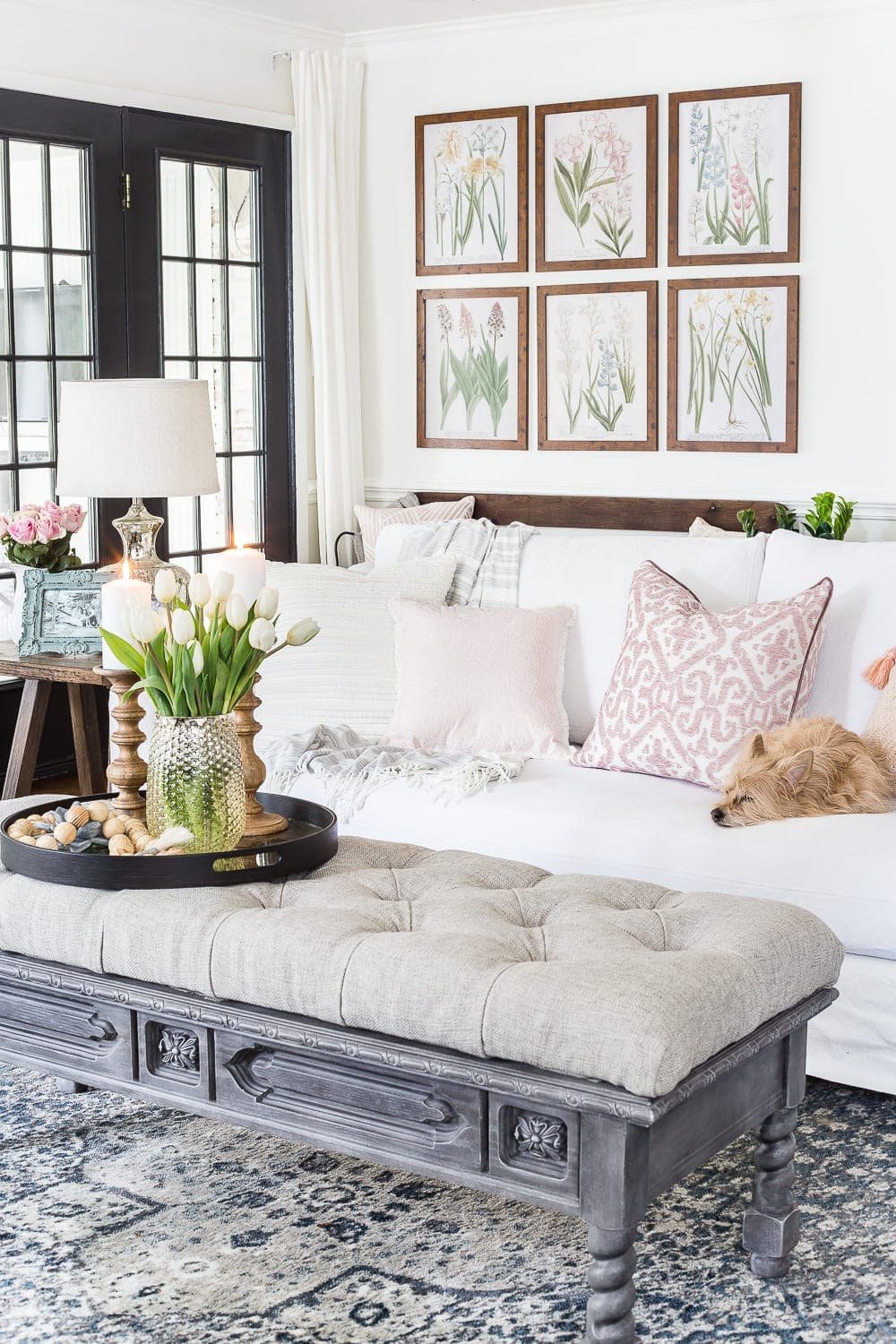 A living room gets a spring refresh with simple florals, candle light, and light fabrics. #springdecor #livingroom #springlivingroom #springaccents #livingroomdesign #livingroomdecor #budgetdecor