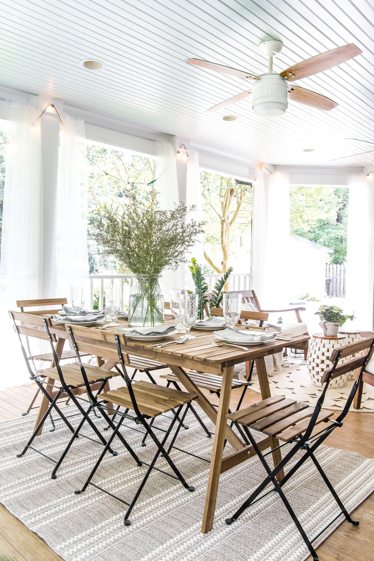 outdoor dining table on back porch with haint blue ceiling and ceiling fan