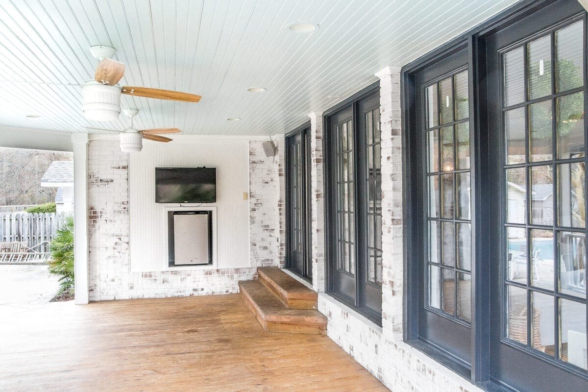 limewashed brick back porch with haint blue ceiling and black doors