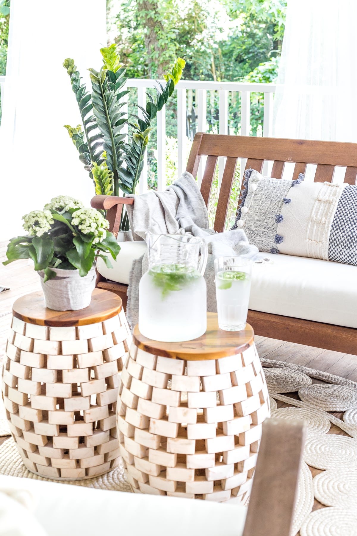 summer decor on back porch with garden stools and outdoor bench