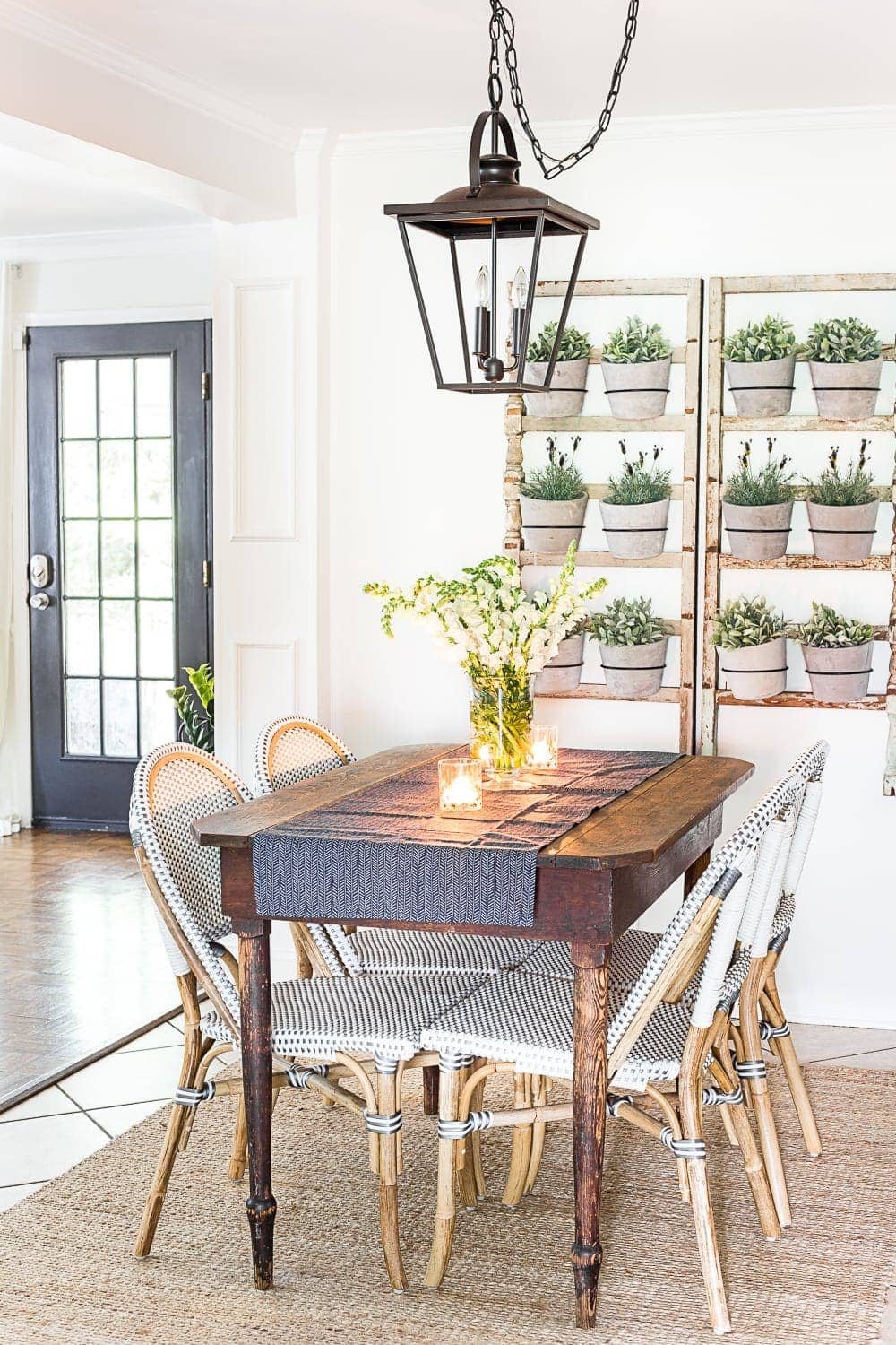 breakfast nook decorated for summer with a DIY wall planter made from antique banisters