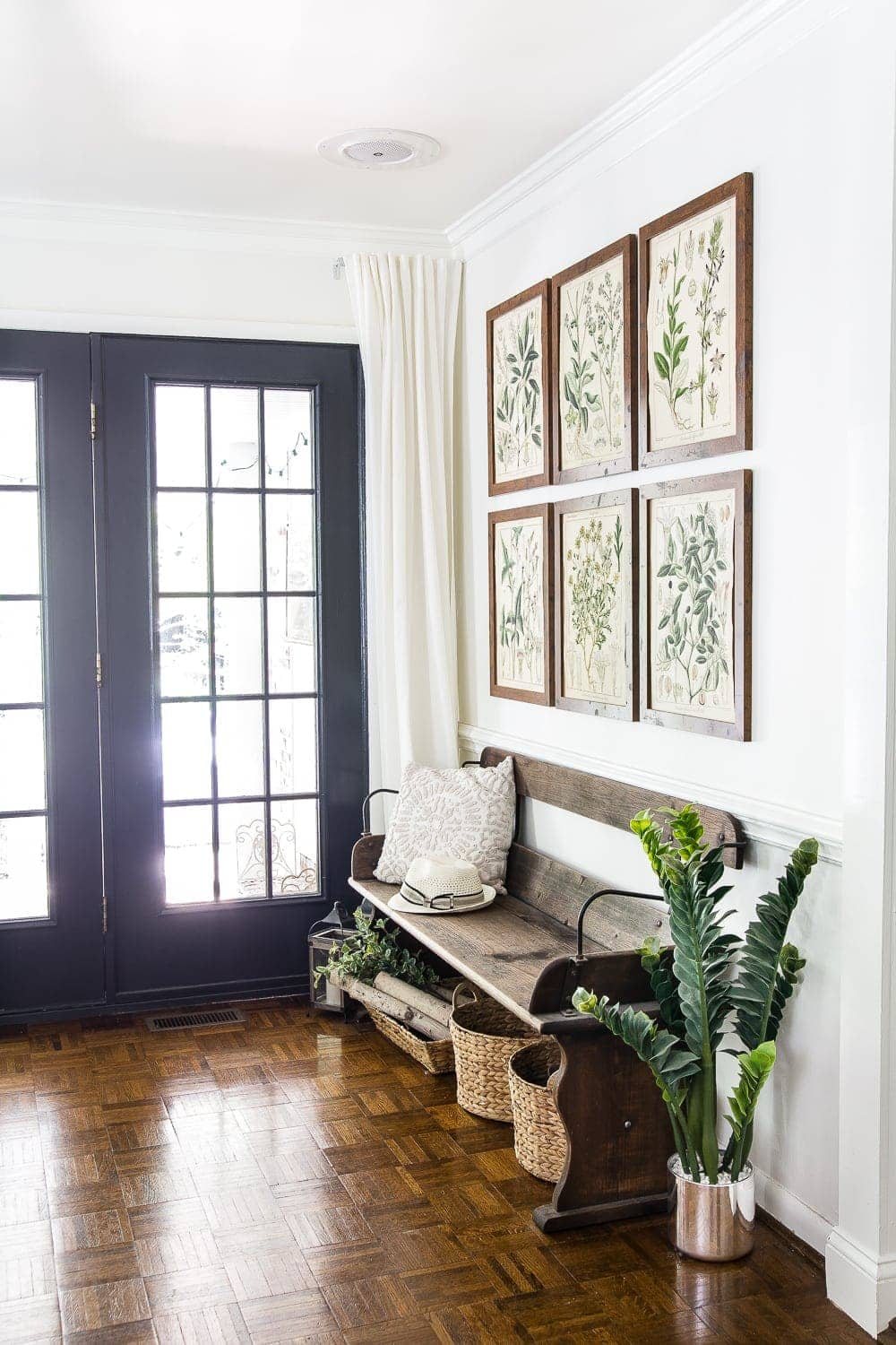 entryway with summer botanical gallery wall and reclaimed wagon bench