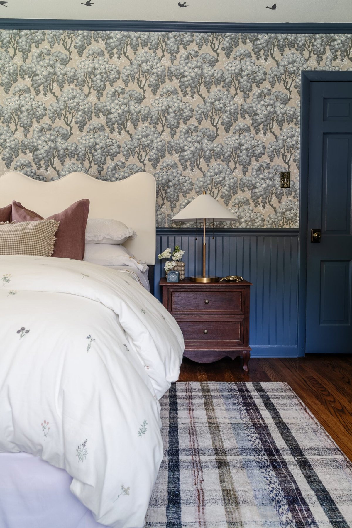 swedish cottage girls bedroom with pattern play bedding, full length mirror, traditional wood nightstand, and modern lamp