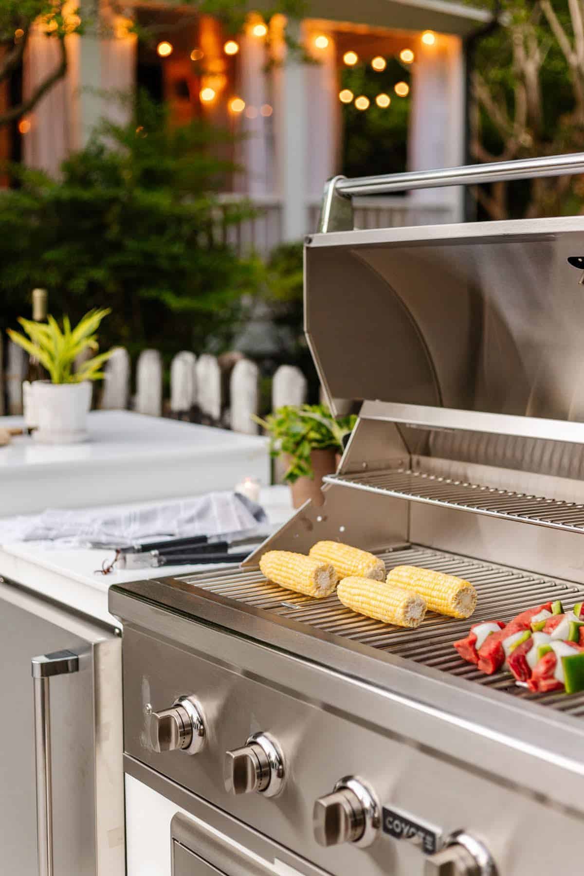 backyard grill with corn on the cob and shish kabobs for a pool party