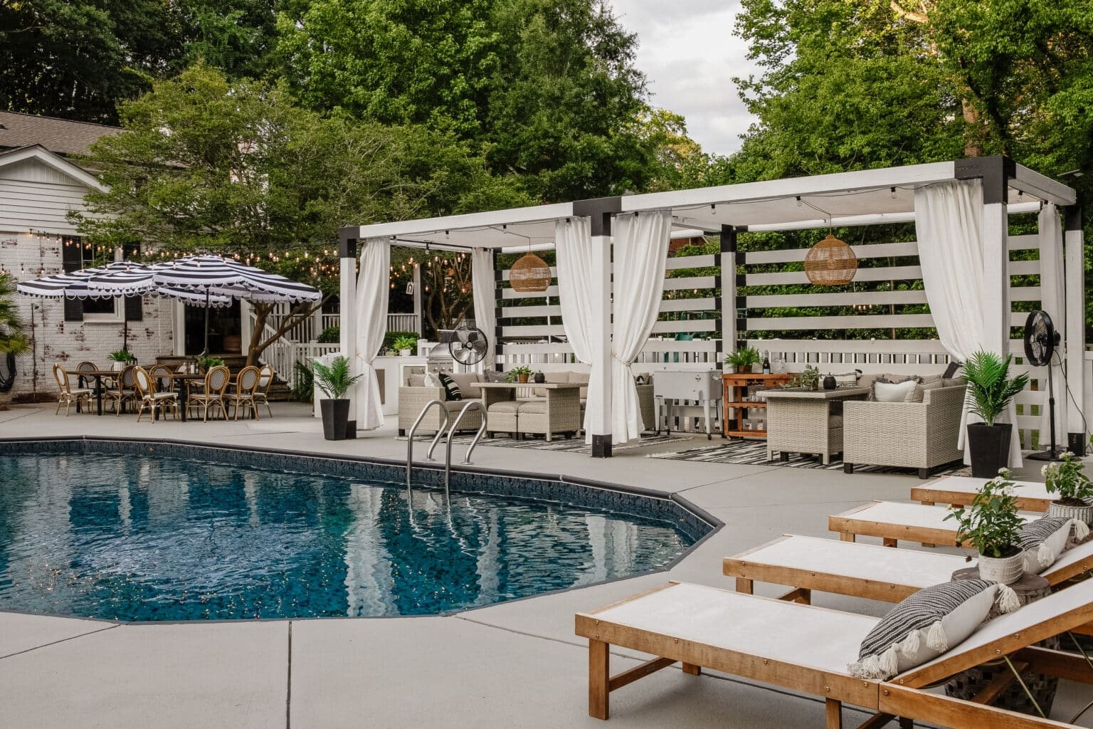 backyard swimming pool with lounge chairs and cabana pergola