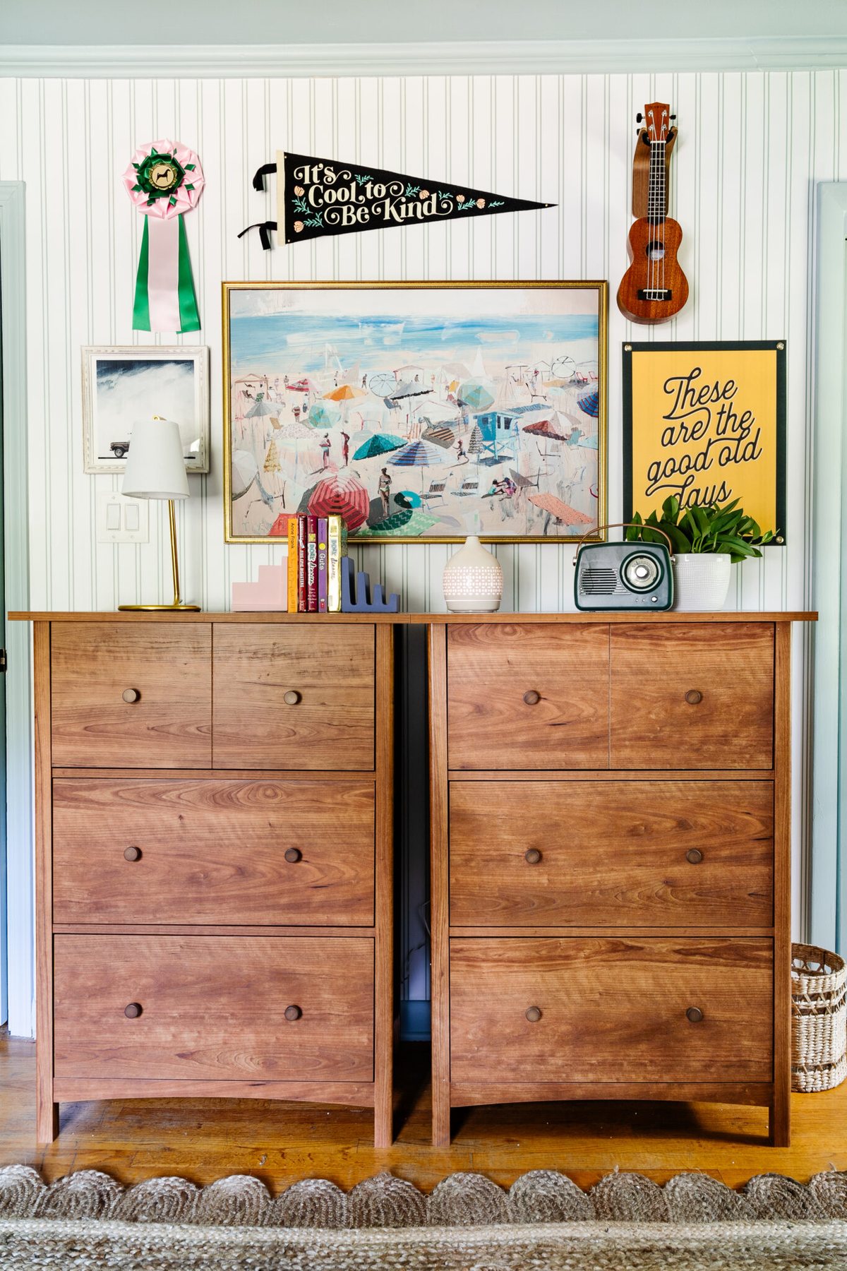 vintage gallery wall in teenage bedroom above dressers with coastal paintings and camp art