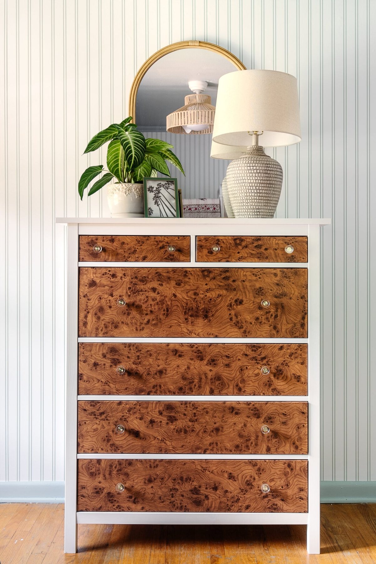 IKEA hack burl wood dresser using contact paper with arched rattan mirror and coastal lamp