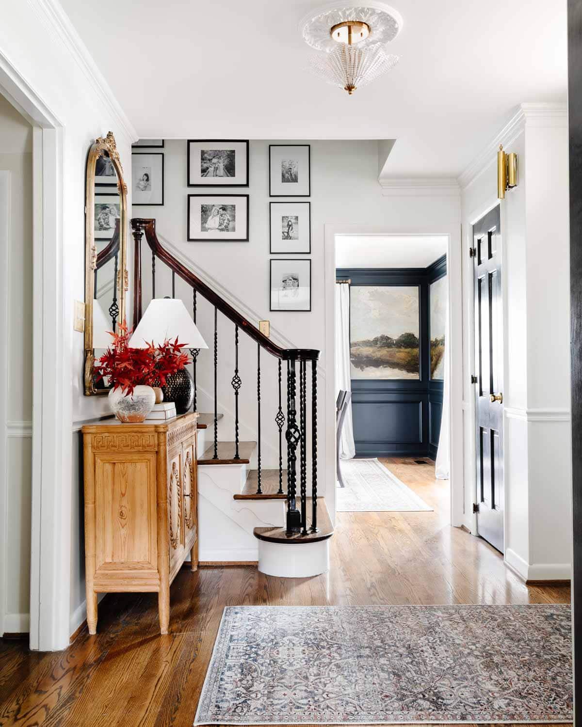 foyer ideas : entryway table, rug, and stairway gallery wall
