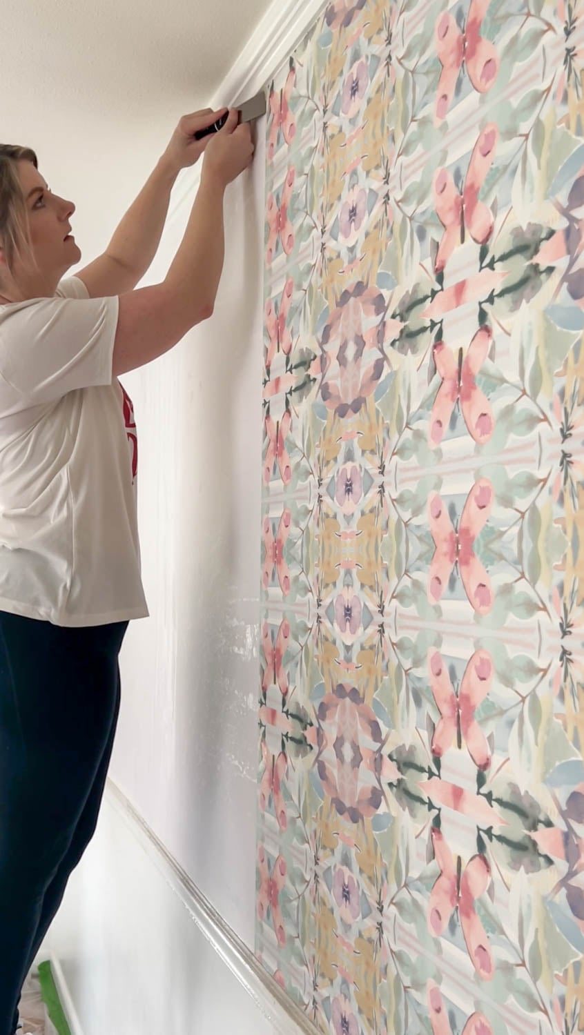 using a putty knife to loosen edges for wallpaper removal