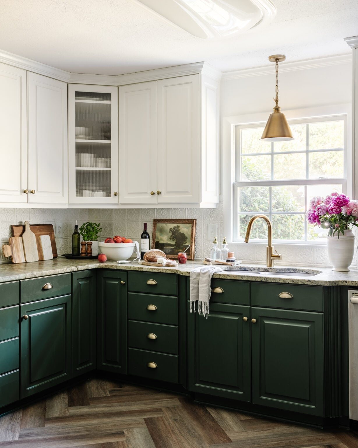 kitchen with white and green cabinets, herringbone floor, pressed tin backsplash, and cottagecore style decor
