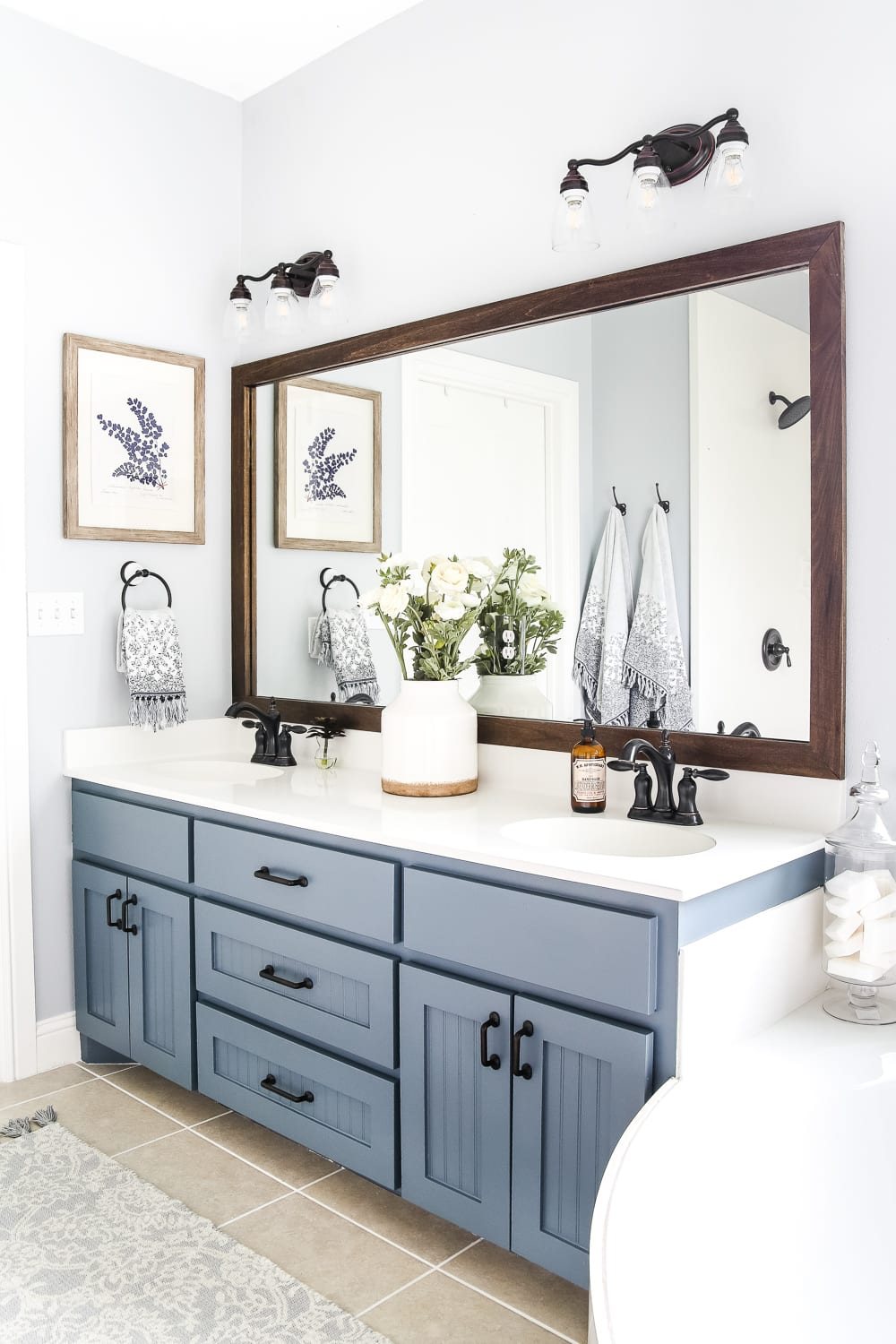 builder grade mirror with DIY wood mirror frame above a double bathroom vanity