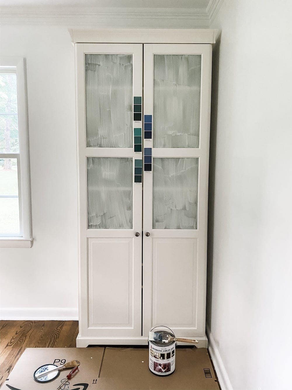 sampling navy blue paint colors on a cabinet