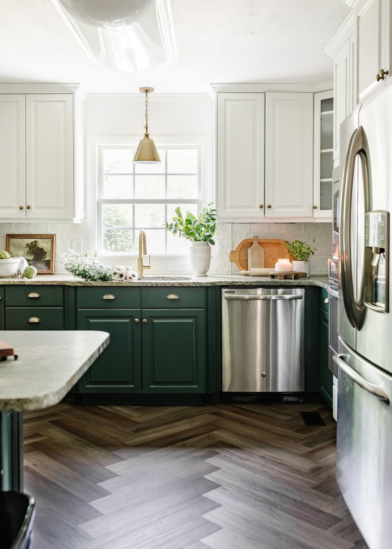 decluttered kitchen with green cabinets and herringbone floor