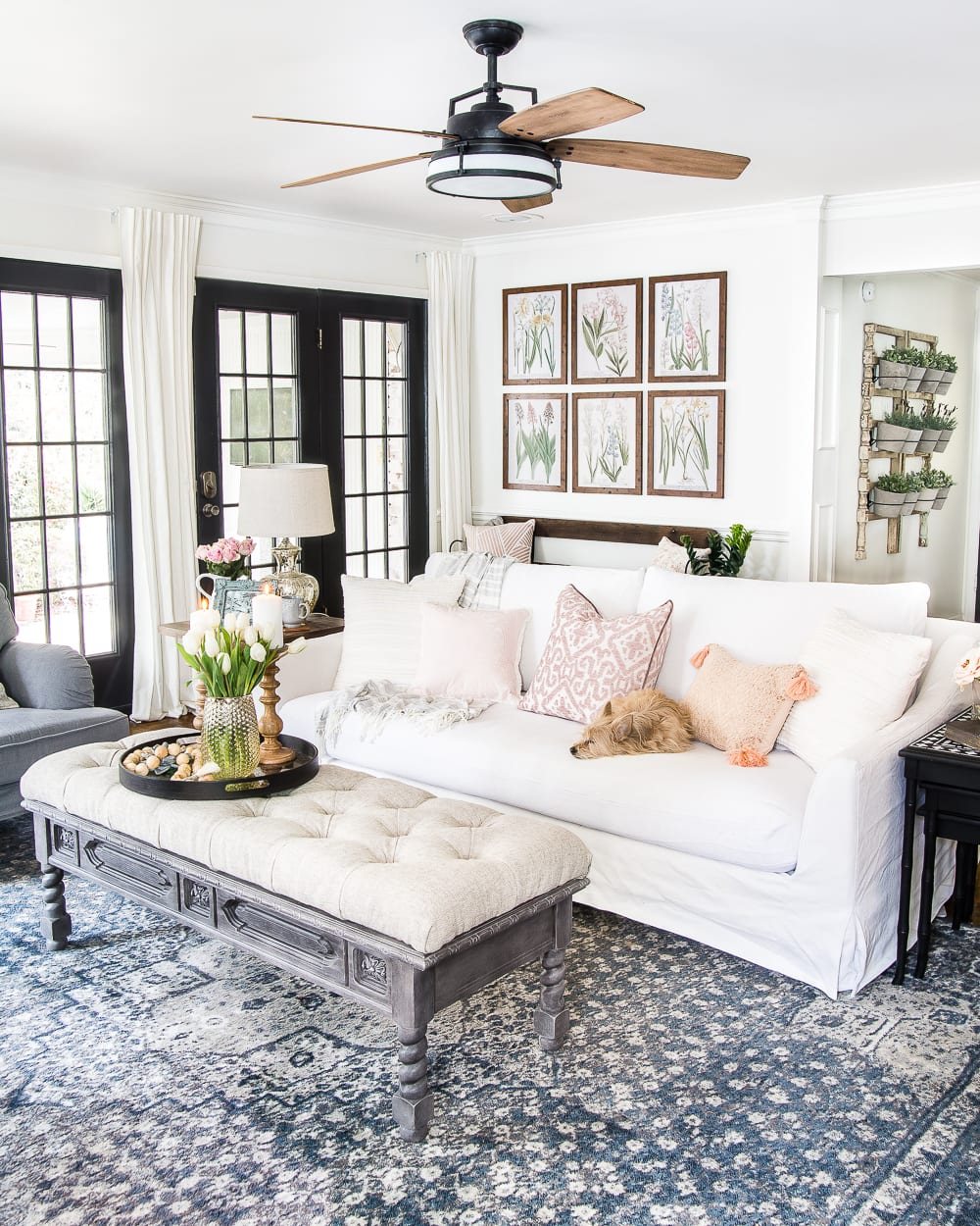 A living room gets a spring refresh with simple florals, candle light, and light fabrics. #springdecor #livingroom #springlivingroom #springaccents #livingroomdesign #livingroomdecor #budgetdecor