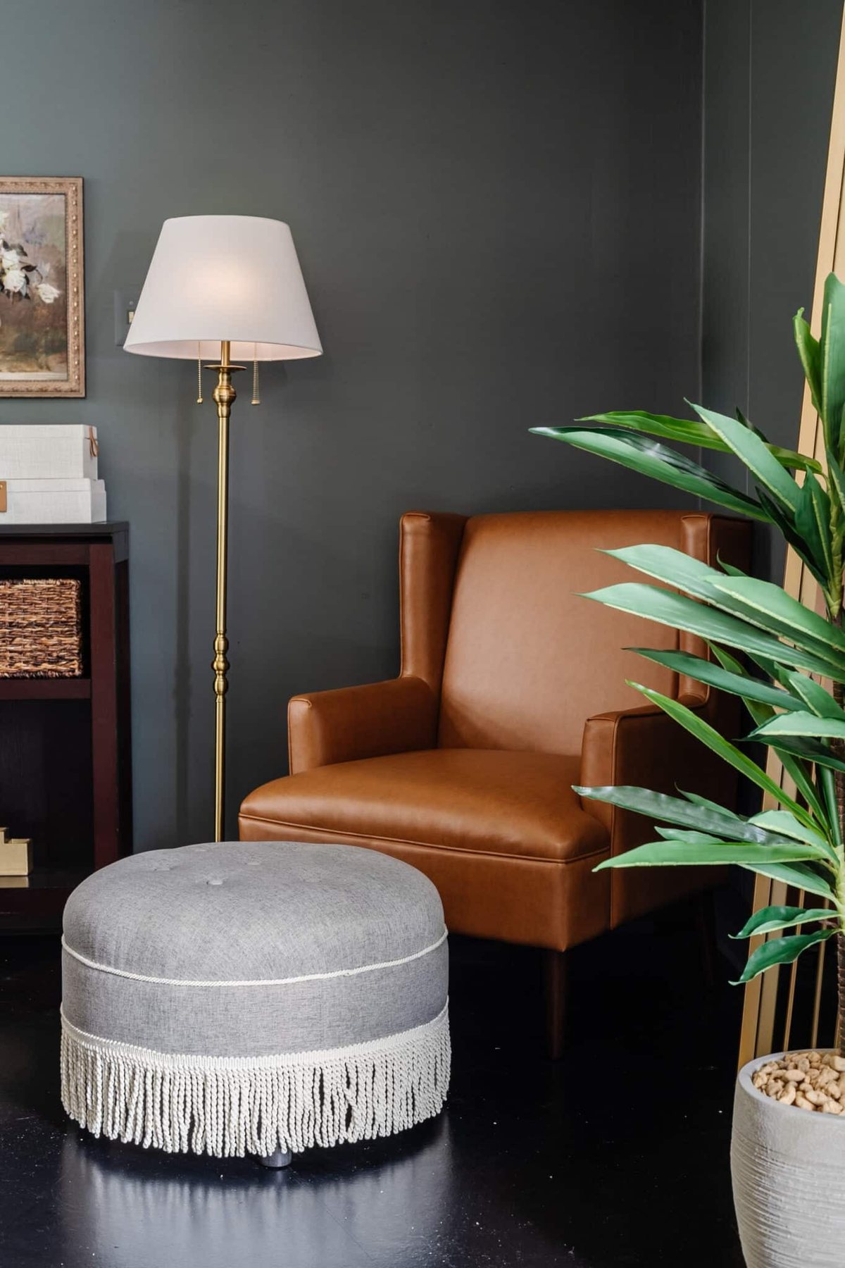 leather armchair with fringe ottoman footstool as a reading corner in an office