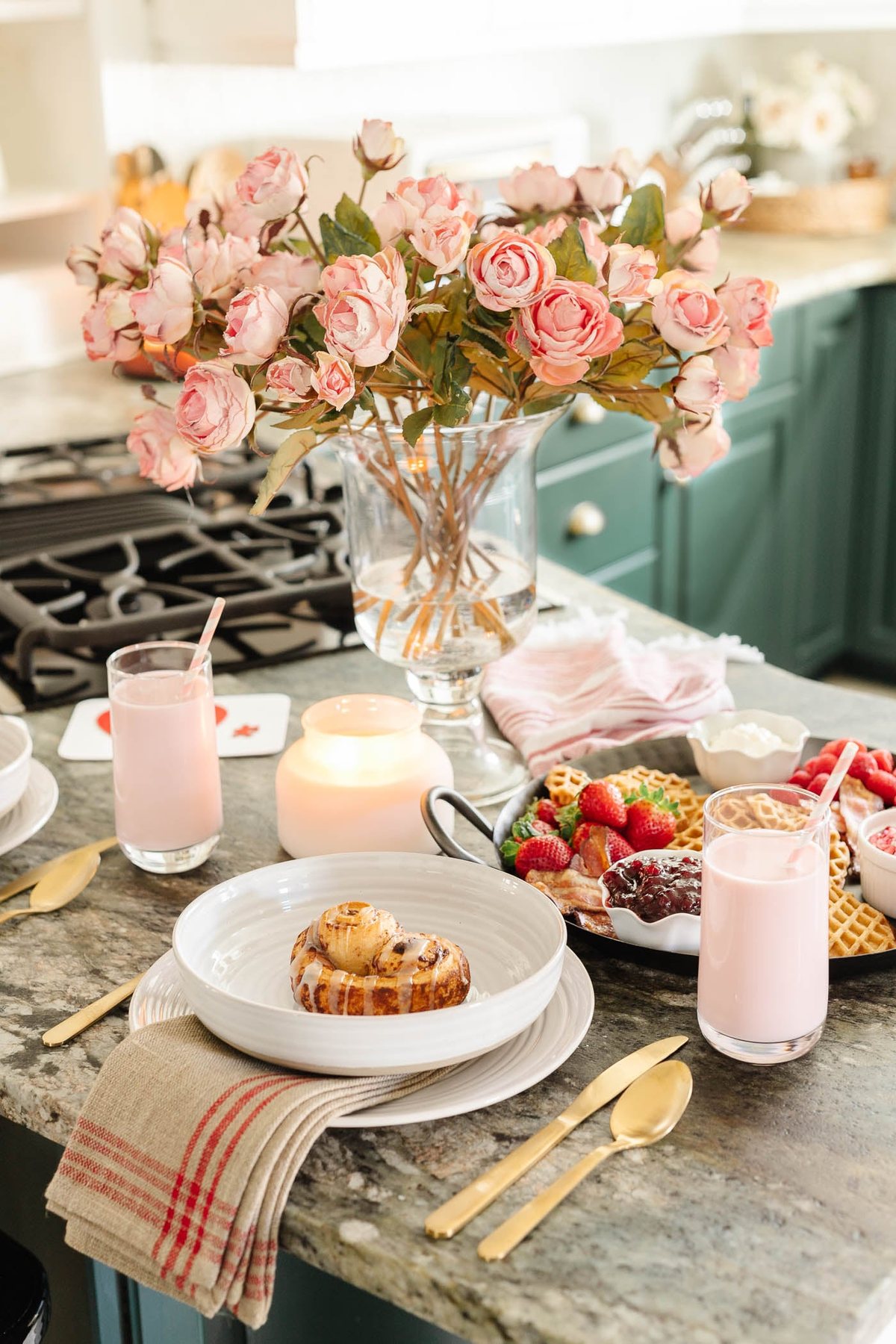 Valentine's Day breakfast charcuterie board with place settings on kitchen counter and pink roses with candles