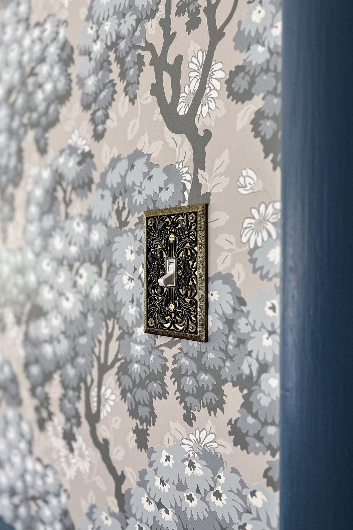 vintage light switch cover on floral swedish wallpaper