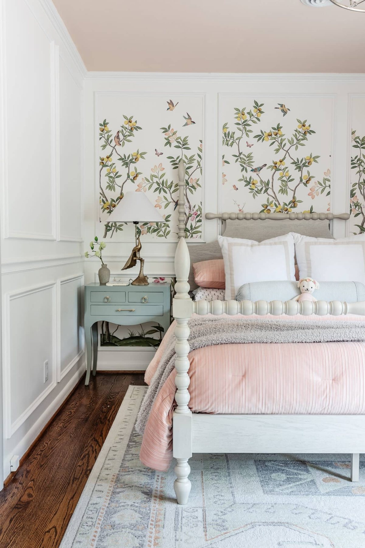 little girl's bedroom with poster bed, chinoiserie wallpaper, and gloss painted bedside table