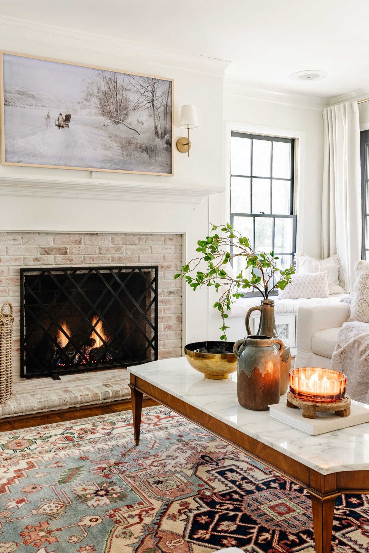 limewashed brick fireplace in a living room with marble top coffee table