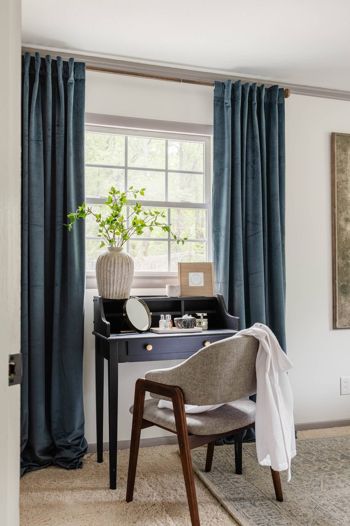 guest bedroom with blue curtains, writing desk in front of window