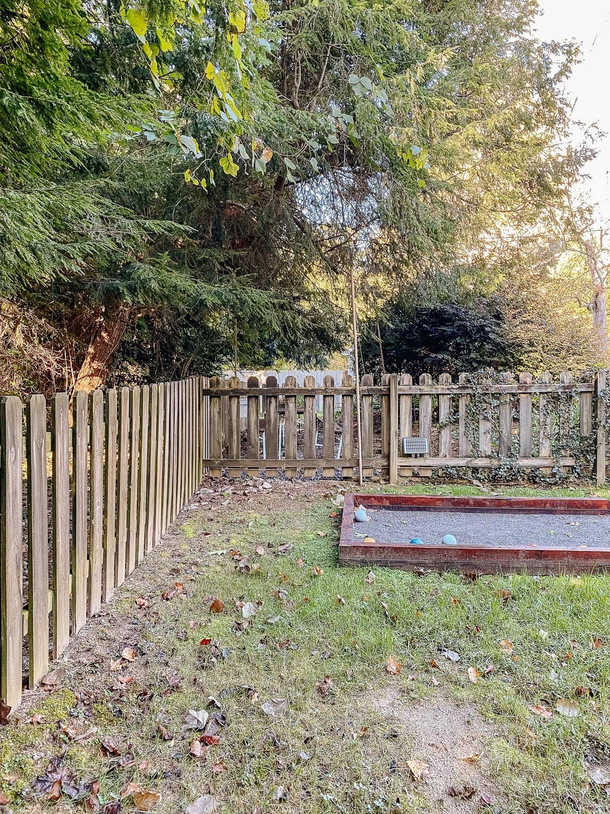 backyard bocce ball court with wood fencd