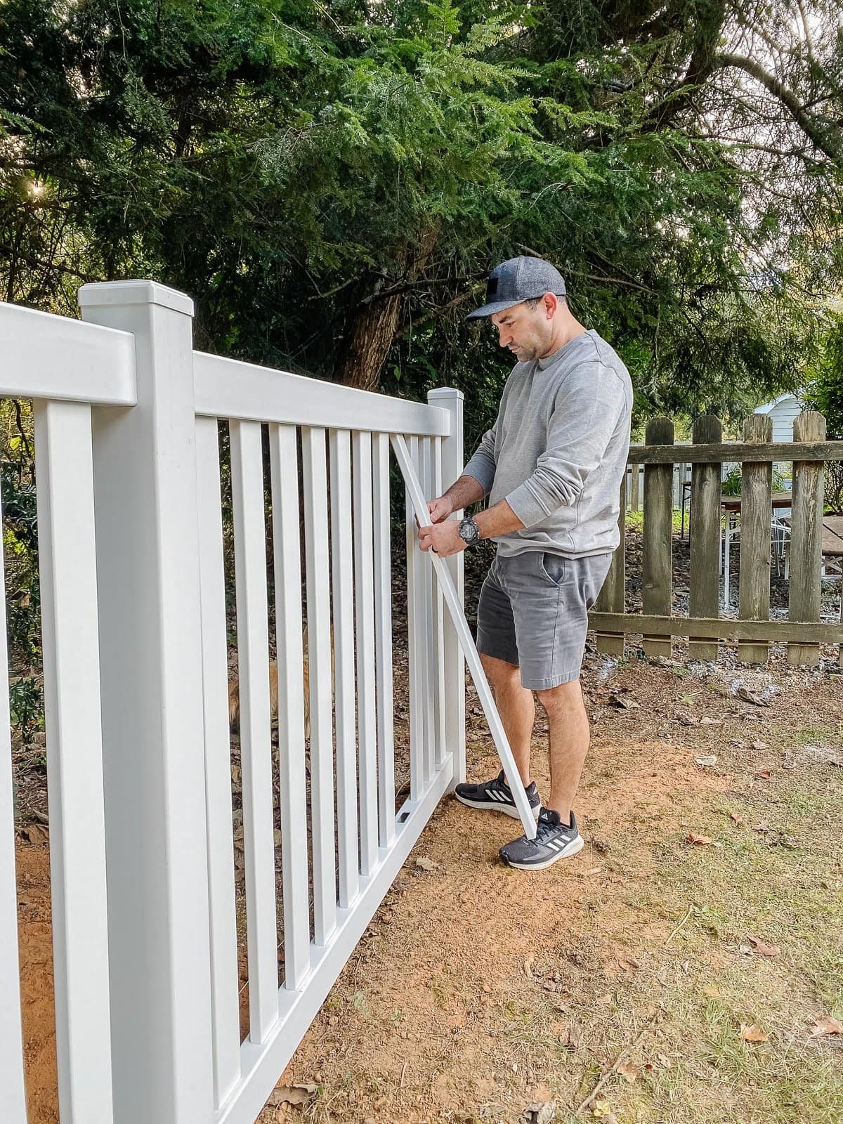 white vinyl fence installation using Ply Gem in a backyard