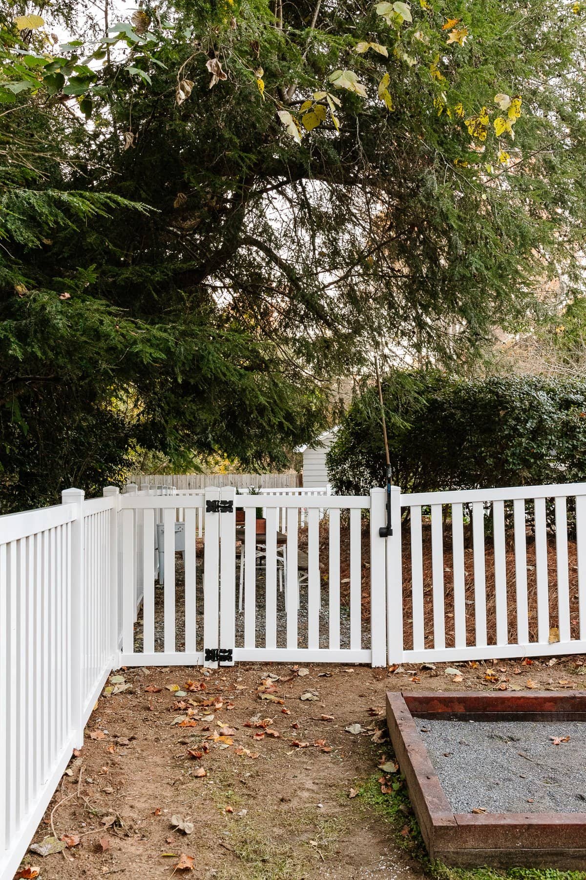 white vinyl fence with gate leading into backyard beer garden