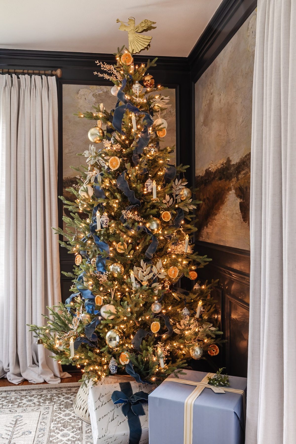 blue Christmas tree decor with ribbon, metallic ornaments, and white and blue ornaments