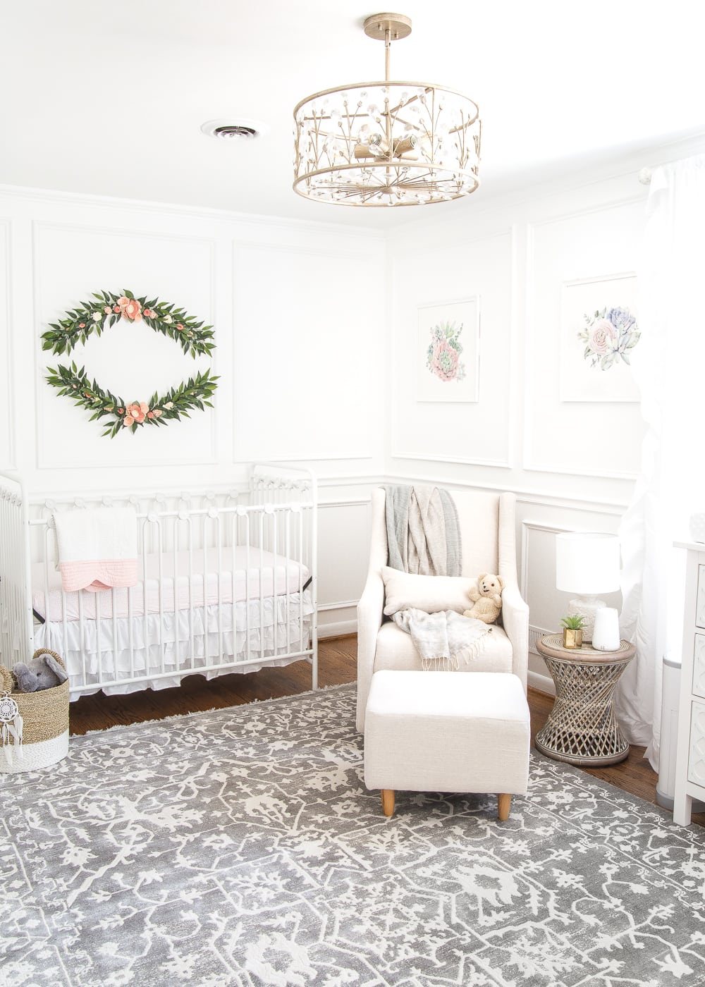 An all white nursery makeover room reveal with classic, vintage style furniture, Anthropologie-inspired patterns and textures, and floral accents.