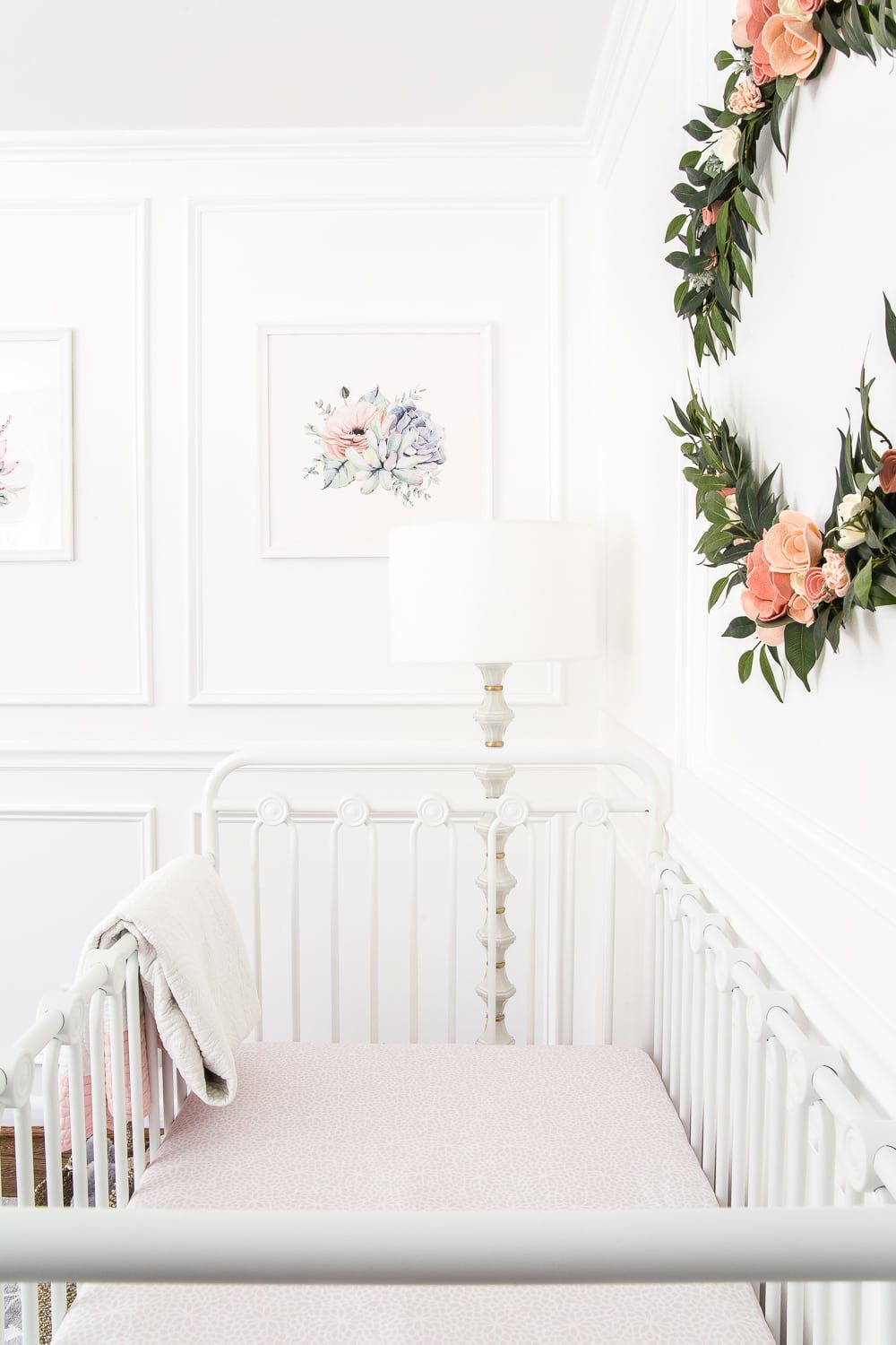An all white nursery makeover room reveal with classic, vintage style furniture, Anthropologie-inspired patterns and textures, and floral accents.