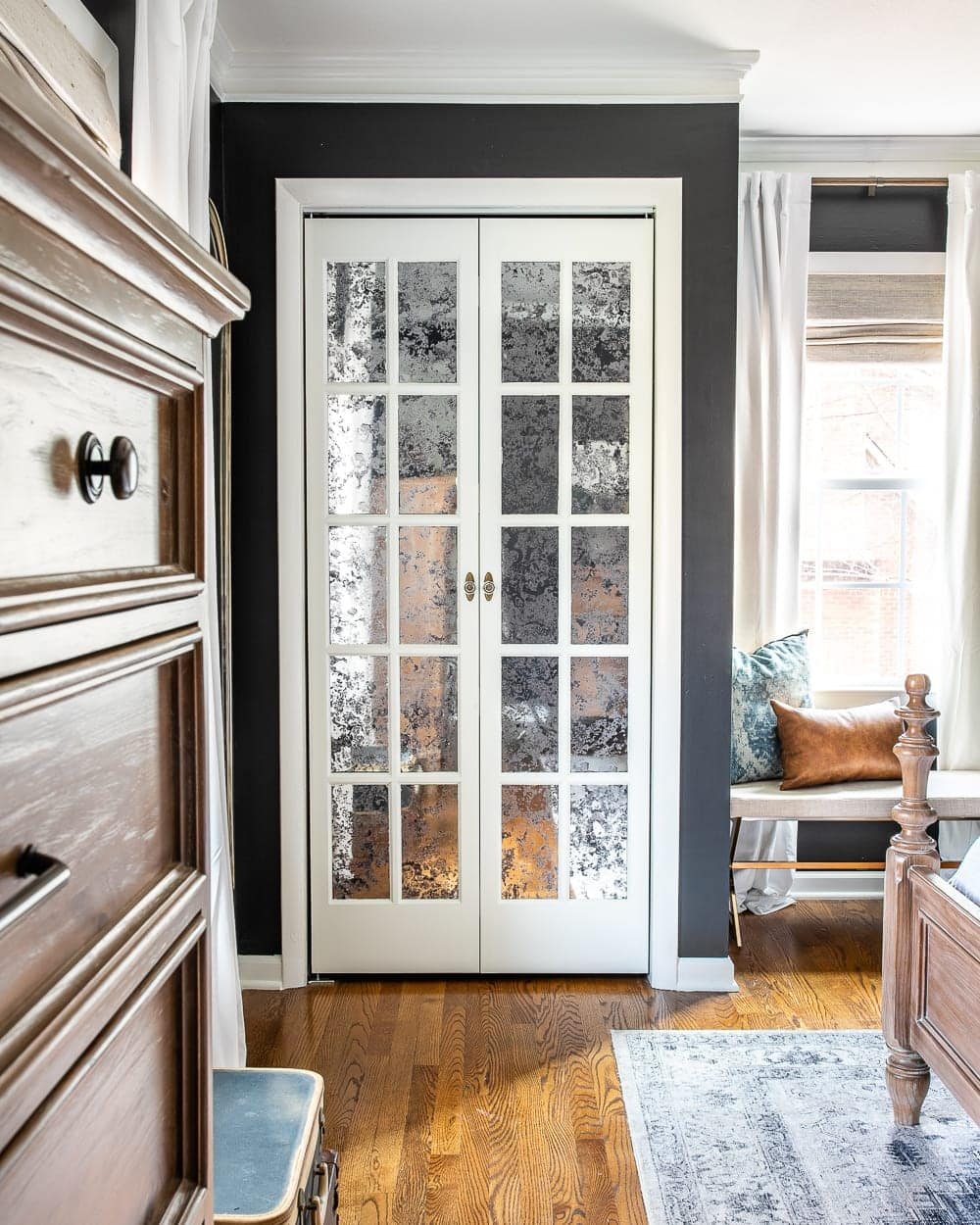 white French bifold door with antique mirror glass film front in a bedroom