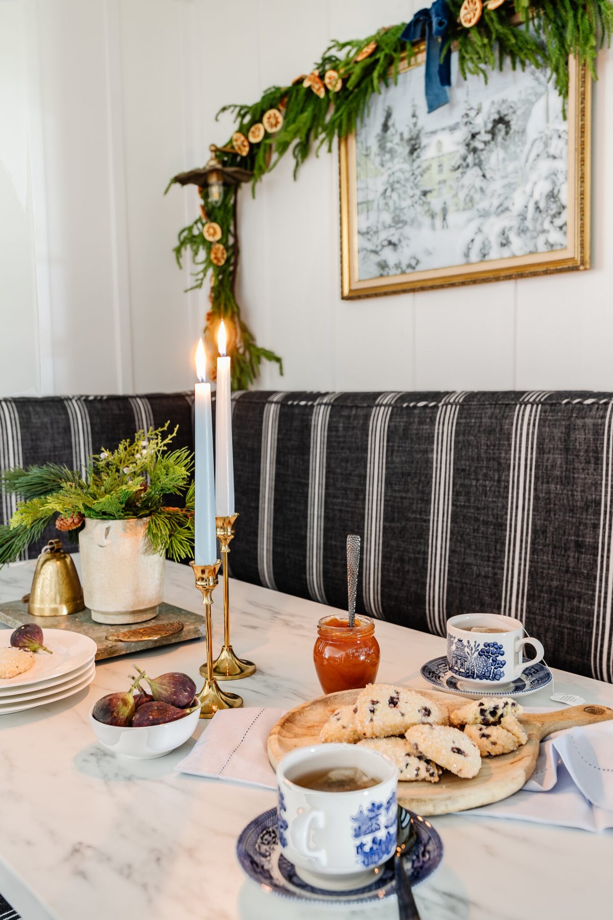 christmas kitchen table with vase of winter greenery, winter painting, and garland