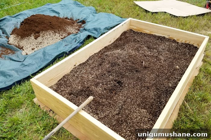 How to Grow a High Yield Raised Bed Vegetable Garden 9 mixing soil, peat moss, vermiculite, and compost together for building a raised bed vegetable garden frame