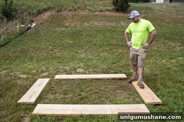 How to Grow a High Yield Raised Bed Vegetable Garden 6 pine boards in a backyard laid out for building a raised bed vegetable garden frame