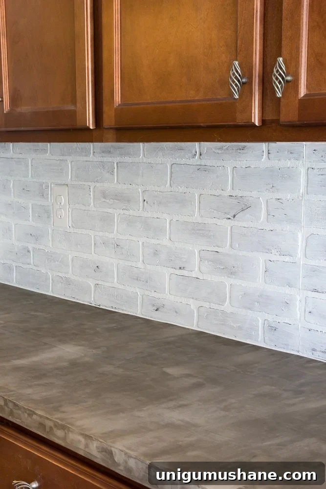 whitewashed faux brick backsplash with concrete countertop